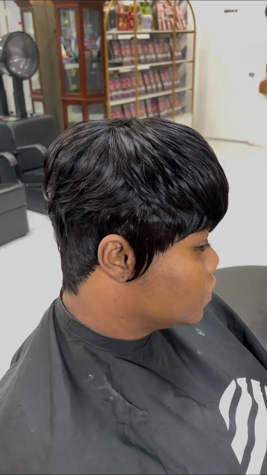Glossy short feathered pixie cut finished at Carmie Hair